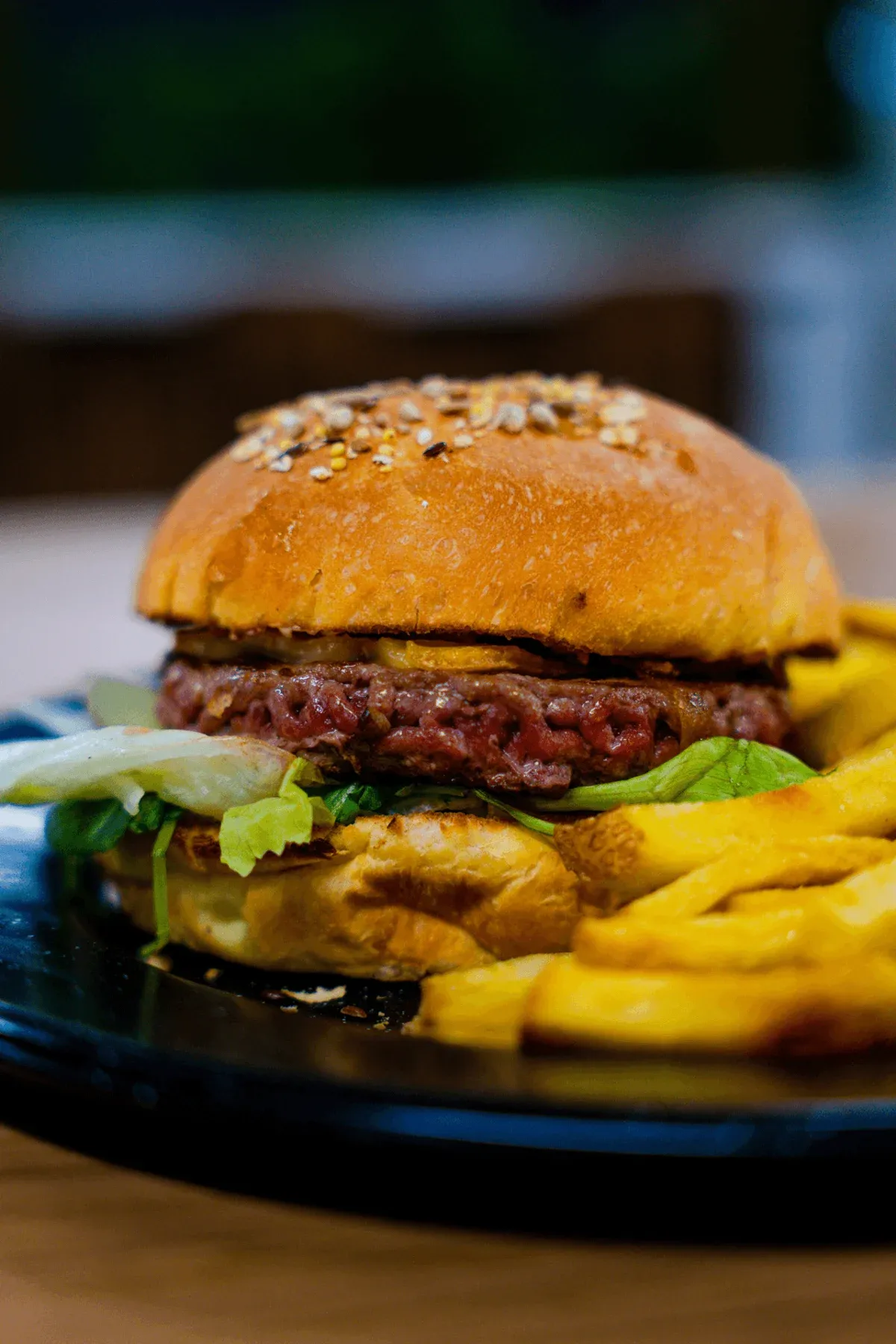 Un burger Papille&Mamille et ses frites maison, servis sur une assiette