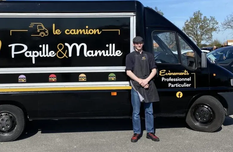 Le camion Papille&Mamille et un membre de l’équipe devant son enseigne